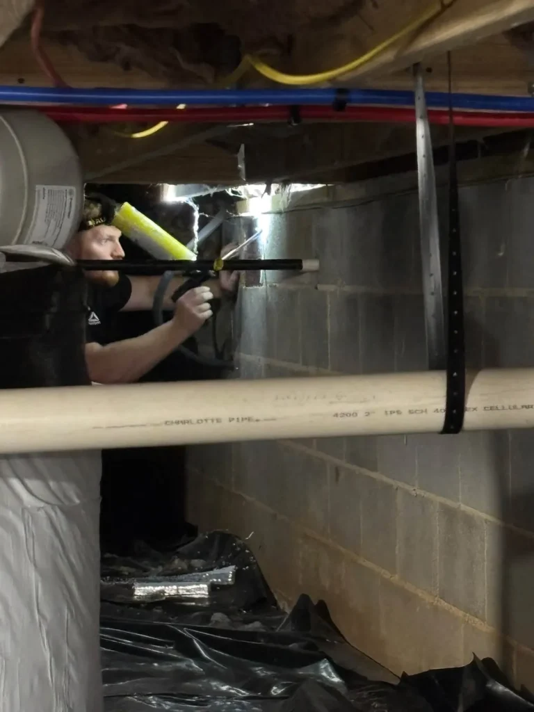 Skeeter's Pest Control technician treating a crawlspace under a home